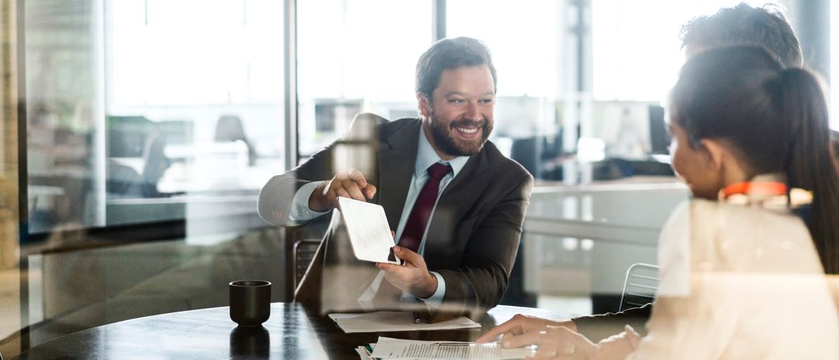 businessman showing a couple information on a tablet screen